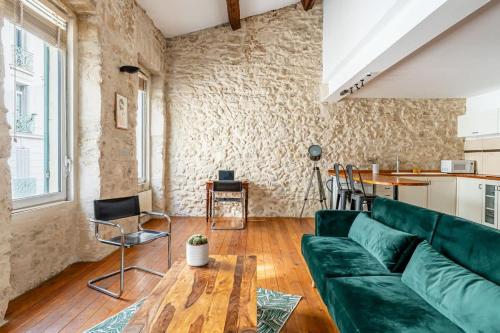 un salon avec un canapé vert et une table dans l'établissement Perle rare a Castellane - Appartement cosy et central, à Marseille