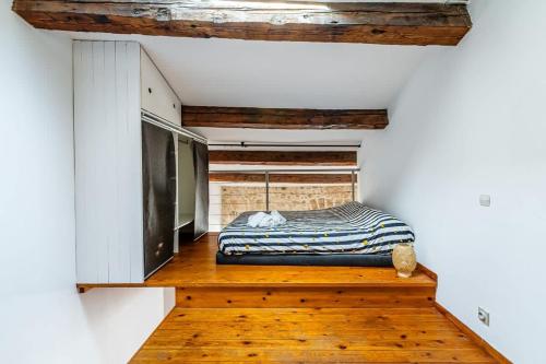 - une petite chambre avec un lit sur du parquet dans l'établissement Perle rare a Castellane - Appartement cosy et central, à Marseille
