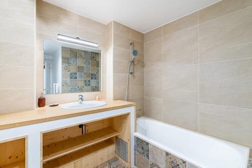 une salle de bain avec un lavabo, une baignoire et un miroir dans l'établissement Perle rare a Castellane - Appartement cosy et central, à Marseille