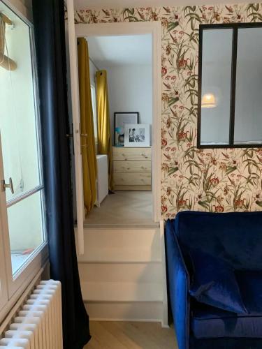 un couloir avec un canapé bleu et un miroir dans l'établissement New & cosy beautiful apt close Marais!, à Paris