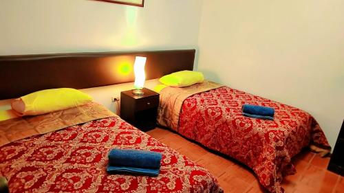 two beds sitting next to each other in a room at Viajeros Centro in Machu Picchu