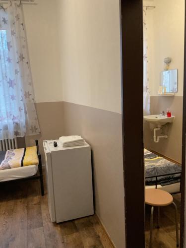 a room with a small refrigerator and a sink at Pension&Hostel Anna - Monteurzimmer -------- 10 minutes walk to Oktoberfest in Munich