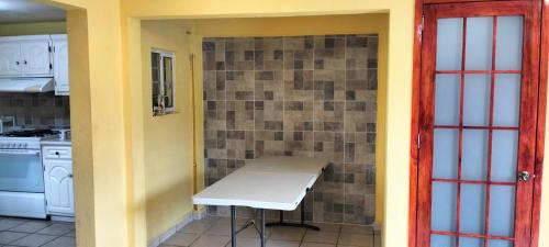 a kitchen with a table and a brick wall at Casa Tlatlauqui in Xotiocuautitla