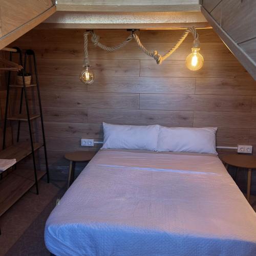 a bed in a room with wooden walls and lights at Calera 2 in Burgos