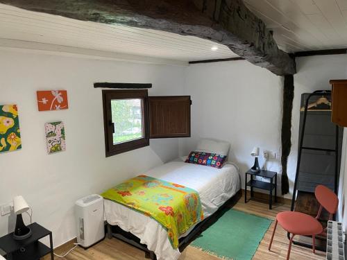 a small bedroom with a bed and a window at Los Paxarinos in Vibaño