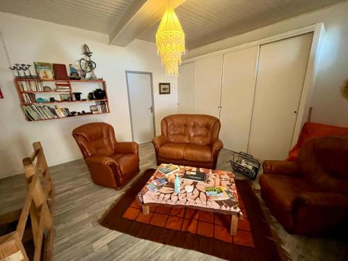 a living room with two chairs and a coffee table at CHAMBRE D HOTES CHEZ DANY MAOWMAOW ET GARFIELD in Bellevue-la-Montagne