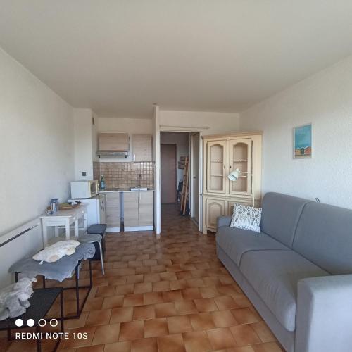 un salon avec un canapé et une cuisine dans l'établissement Appartement vue mer, à Bandol
