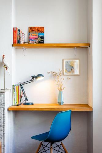 un bureau avec une chaise bleue et une lampe dans l'établissement Immersion au coeur de Marseille - proche Gare et Canebiere et hyper-centre, à Marseille