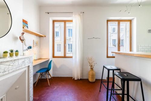 une cuisine avec un comptoir et des tabourets dans une pièce dans l'établissement Immersion au coeur de Marseille - proche Gare et Canebiere et hyper-centre, à Marseille