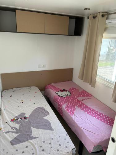 a bedroom with two twin beds and a window at Mobile home sirène luxe Camping le Bosc 4 étoiles 3 chambres in Saint-Cyprien