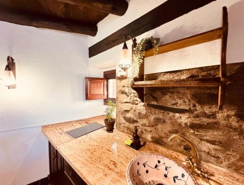 łazienka z umywalką i kamienną ścianą w obiekcie Molino de Santa Águeda w mieście Jerez del Marquesado