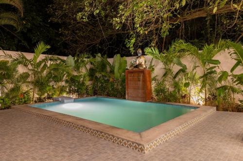 a small swimming pool with a statue sitting on a table at 6BR Luxe Villa with Pool Near Beach in Candolim