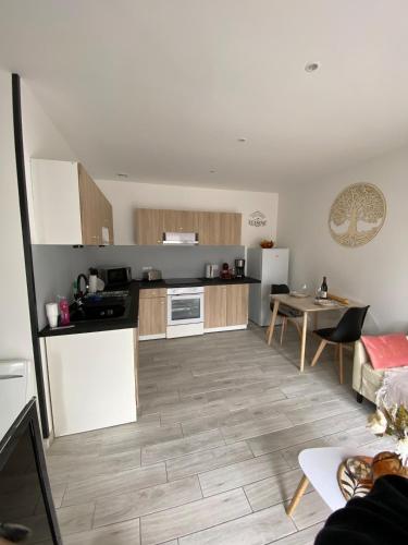 un salon avec une cuisine et une table dans l'établissement Le nid Clémentin, à Saint-Clément