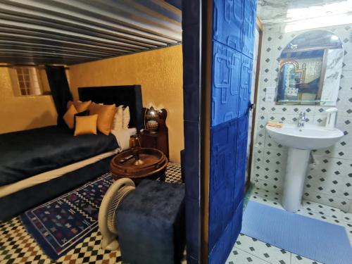 een slaapkamer met een bed en een wastafel bij Charmant appartement avec terrasse privee a fes medina in Fès