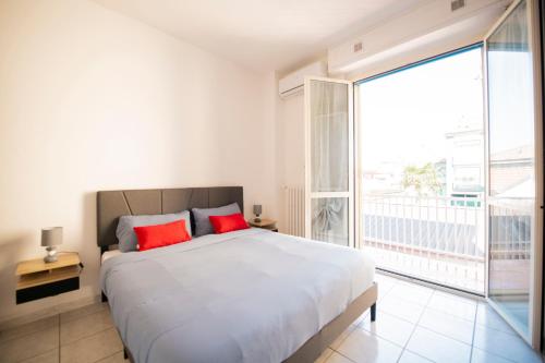 ロッツァーノにあるLa Maison di Grace vicino Humanitas & Forumの大きなベッドと大きな窓のある寝室