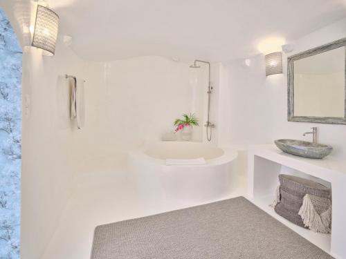 ein weißes Badezimmer mit Waschbecken und Spiegel in der Unterkunft Luxurious Studio Vasiliki in Hydra