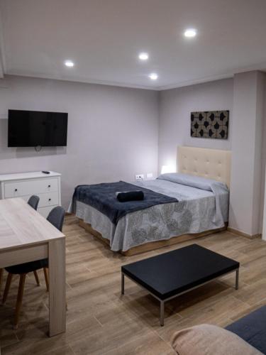 a bedroom with two beds and a tv on the wall at Casa Lavanda in Villena