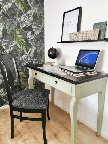 a desk with a laptop on it with a chair at NUMMER EiNS in Neuötting