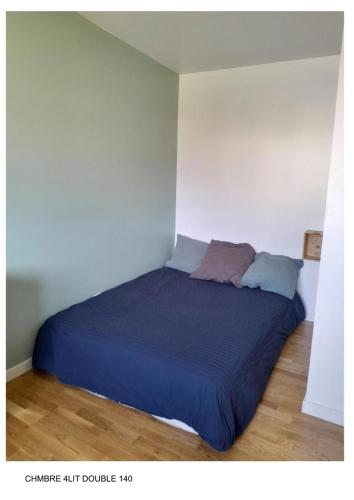 - un lit avec une couette bleue dans l'établissement La maison du créac'h, à Lampaul-Plouarzel