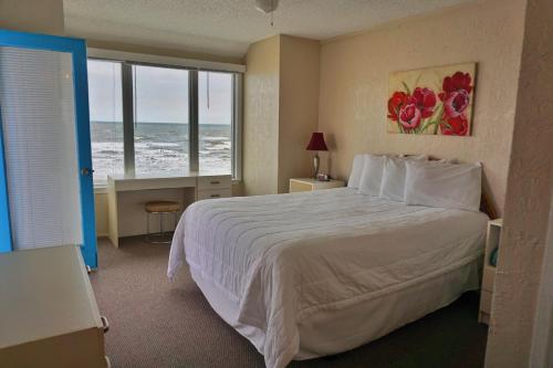 a hotel room with a bed and a window with the ocean at Four Seasons on the Gulf in Galveston