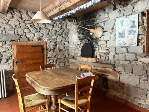 une salle à manger avec une table et des chaises en bois dans l'établissement Gîte rural le four à pain dans le parc naturel du Haut Jura, à La Pesse