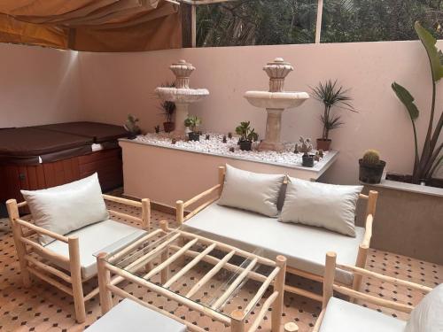 a patio with two chairs and a fountain at Duplex Sur Marrakech Guéliz in Marrakech