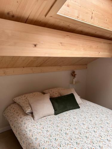 a bed in a bedroom with a wooden ceiling at Le Mélèze, chaleureux appartement 4pers près de Genève & Annecy in Saint-Germain-sur-Rhône