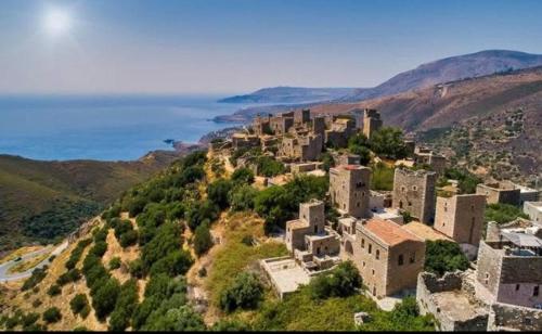 a village on top of a hill with the ocean at Pezula Mani in Gerolimenas