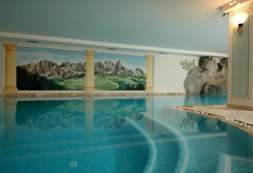 a swimming pool with a painting on the wall at Residence Pez Gajard in San Martino di Castrozza