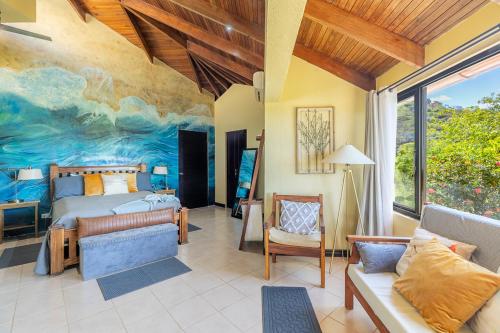 a bedroom with a bed and a painting on the wall at Villa Sunset - Your Sunshine Escape! in Ocotal