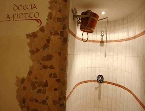 a shower in a bathroom with a stone wall at Residence Pez Gajard in San Martino di Castrozza