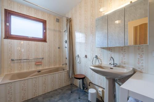 une salle de bain avec un lavabo et une baignoire et un lavabo dans l'établissement Entre Lac & Montagnes Spacieux Appartement 6 pers, à Alex