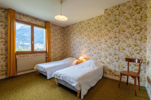 une chambre avec deux lits et une chaise et une fenêtre dans l'établissement Entre Lac & Montagnes Spacieux Appartement 6 pers, à Alex