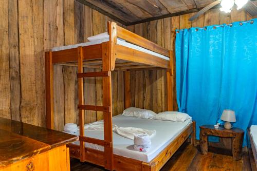 a bedroom with a bunk bed in a wooden room at Citronela Lodge Corcovado in Drake