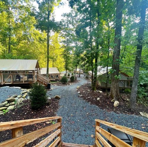 a path in the woods with a fence at Outdoor Adventure Retreats - Wilderness Cove Campground in Saluda
