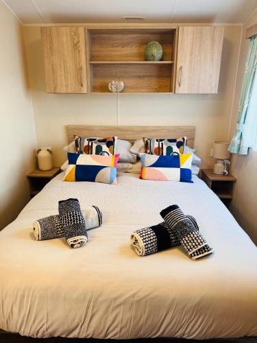 a bedroom with two beds with pillows on them at Little Cha-Am Caravan Hire at Silver Sands in Lossiemouth