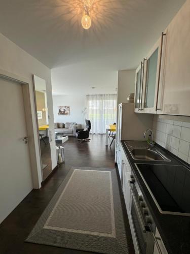 a kitchen with a sink and a living room at Schicke Ferienwohnung am Golfplatz in Bad Bellingen