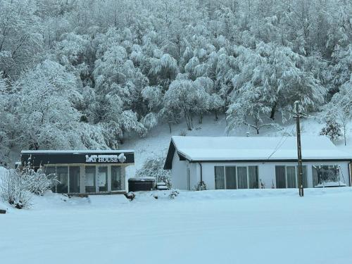 a building covered in snow in front of a forest at Lay House in Şuncuiuş
