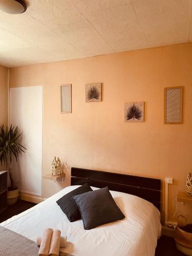 une chambre avec un grand lit blanc avec des oreillers noirs dans l'établissement Bar du Marché - Hôtel - Restaurant, à Langeais