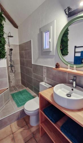 a bathroom with a sink and a toilet and a mirror at L'Original, Superbe appartement à 5min de la plage in Zonza