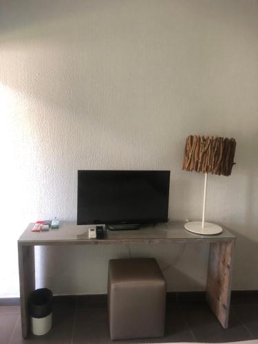 a desk with a computer and a lamp on it at Karukéra in Saint-François
