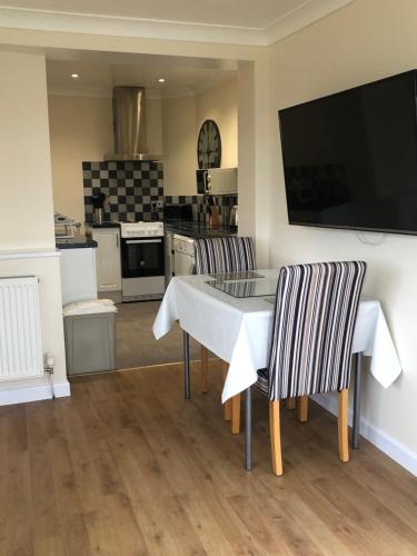 a kitchen with a table and two chairs and a television at Seaclusion in St Austell