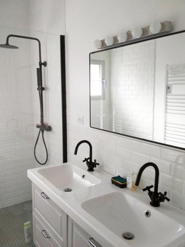 une salle de bain avec un lavabo et un grand miroir dans l'établissement maison familiale climatisée piscine, à Blanquefort