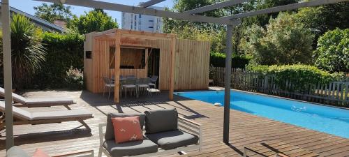 une cour avec une pergola en bois à côté d'une piscine dans l'établissement maison familiale climatisée piscine, à Blanquefort