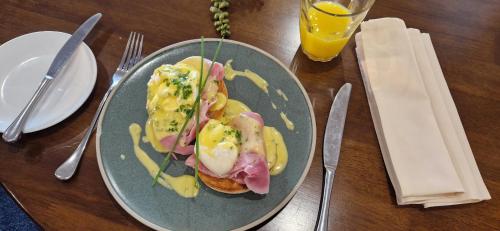 a plate of food with eggs and ham on a table at Dunkerley's Hotel and Restaurant in Deal