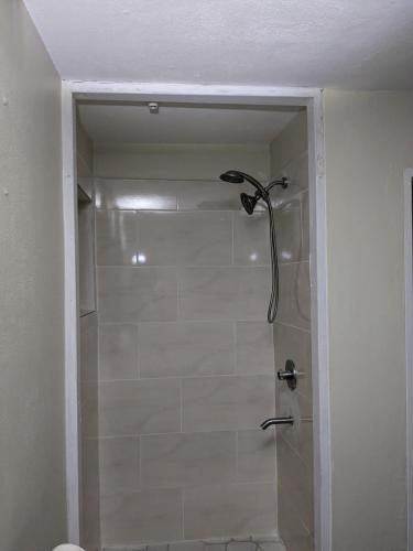 a shower in a bathroom with a glass door at BridgeView Arcadia One in Portmore