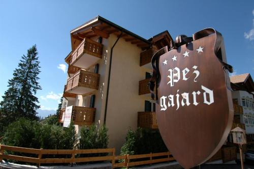 a building with a guitar sign in front of it at Residence Pez Gajard in San Martino di Castrozza