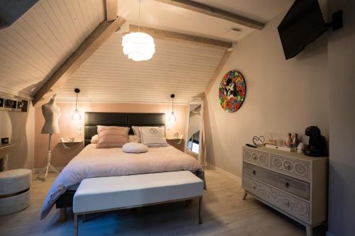 a bedroom with a large bed and a large light fixture at La Maison de Judith Chambres d hôtes in Orthez