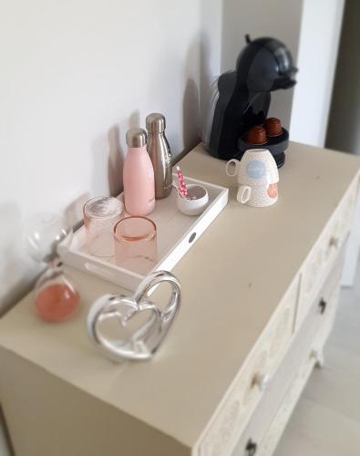 a white counter with a shelf with items on it at La Maison de Judith Chambres d hôtes in Orthez