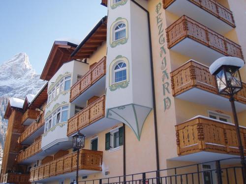 a hotel with wooden balconies and the matterhorn at Residence Pez Gajard in San Martino di Castrozza